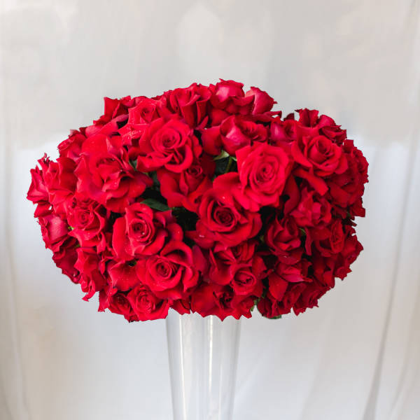 Red rose bouquet in a tall clear glass vase