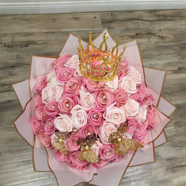 Pink rose bouquet with a gold crown topper and butterfly accents