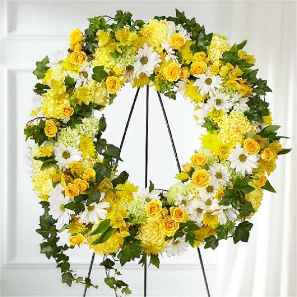 Yellow and white floral wreath on a black stand