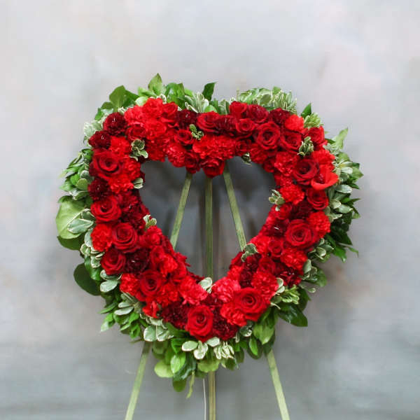 Heart-shaped red floral wreath on a standing easel