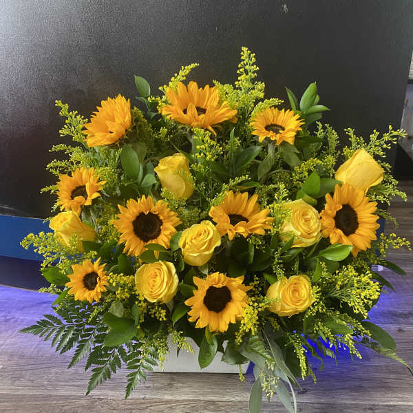 Yellow sunflowers and roses in a low rectangular arrangement