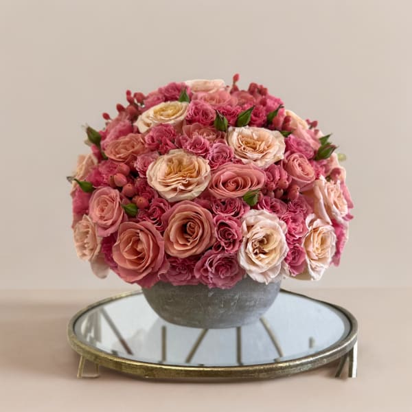 Pink and peach rose arrangement in a gray bowl vase