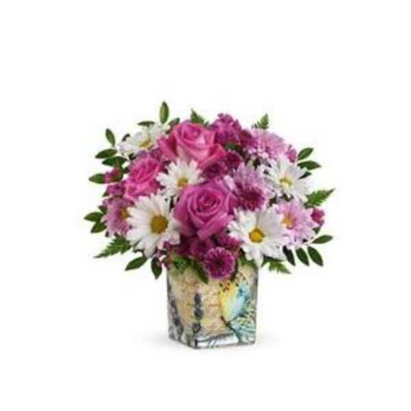 Pink roses and white daisies in a patterned square vase
