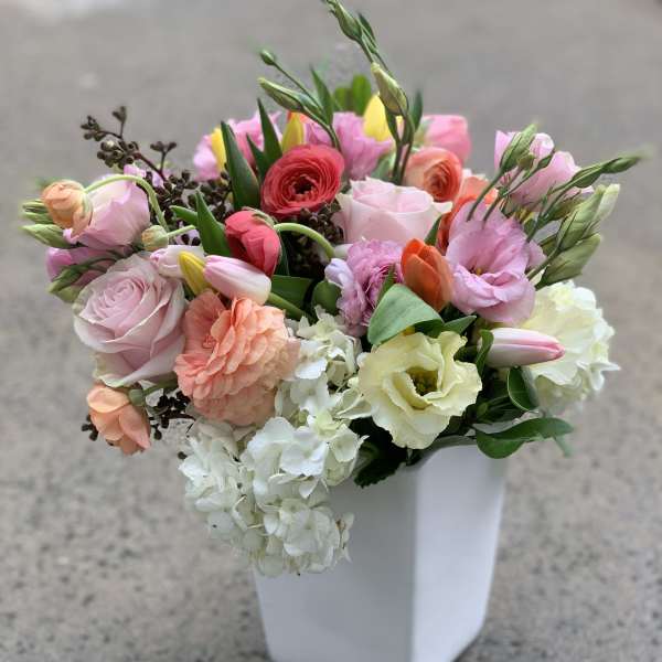 Mixed pastel bouquet in a white square vase