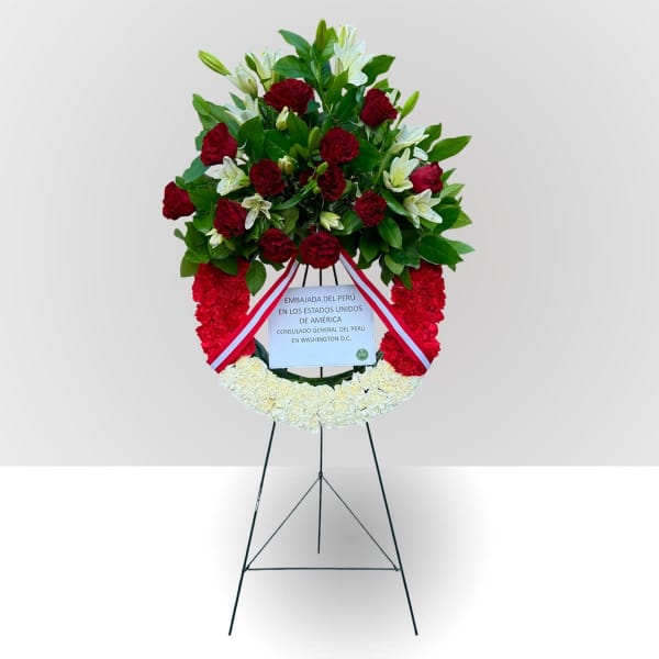 Standing floral wreath with red and white flowers on an easel