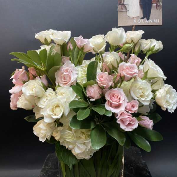 Pink and white roses arranged in a clear glass vase