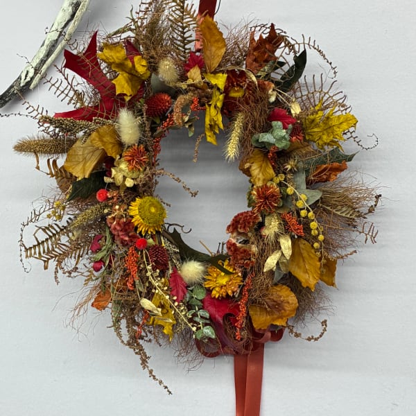 Autumn wreath with dried flowers and leaves on a white background
