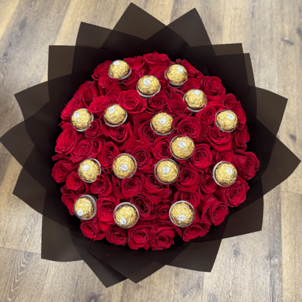 Round bouquet of red roses with gold-wrapped chocolates in black paper wrap