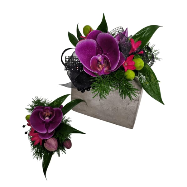 Purple orchid arrangement with pink accents in a gray container, plus a matching corsage