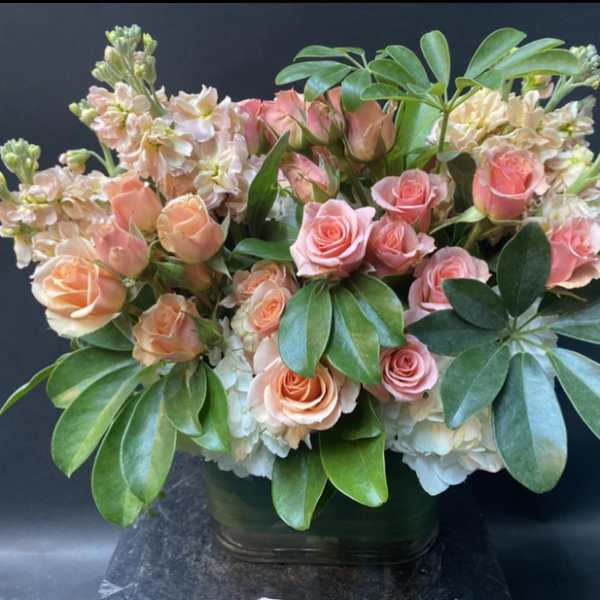 Pink and peach roses arranged in a glass vase