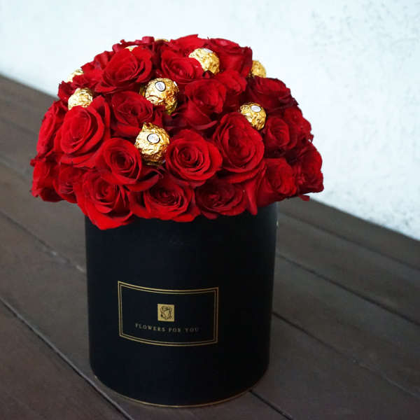 Red roses with gold chocolates in a black box