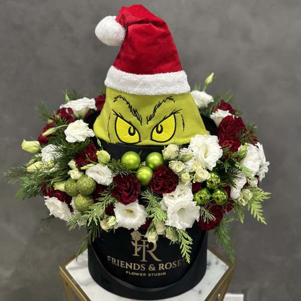 Holiday flower box with red and white roses and a Grinch hat topper