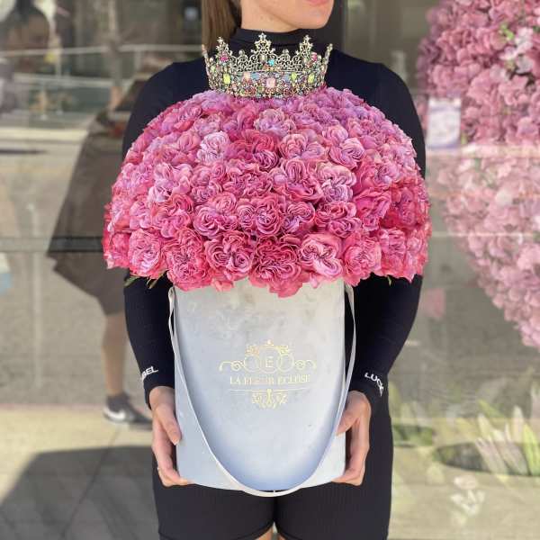 Pink rose bouquet in a pale blue box with a jeweled crown on top