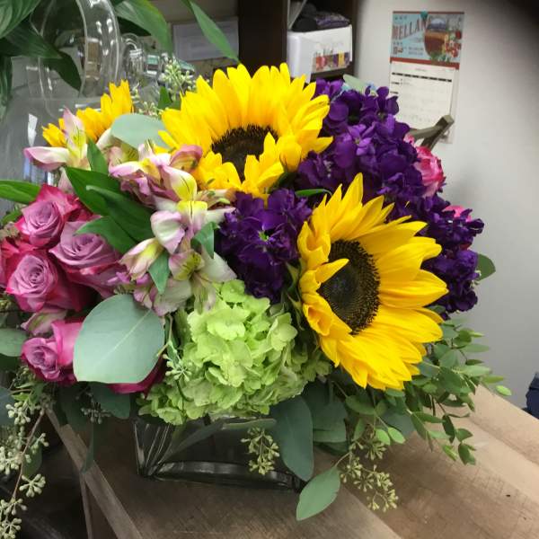 Bouquet with sunflowers, pink roses, purple blooms, and green hydrangea