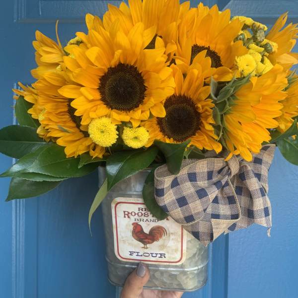 Sunflower bouquet in a metal flour tin with a plaid bow