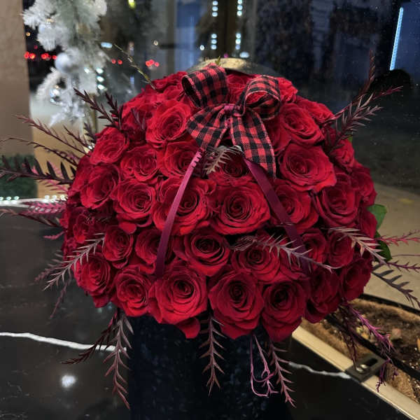 Red rose bouquet with a plaid bow in a black vase