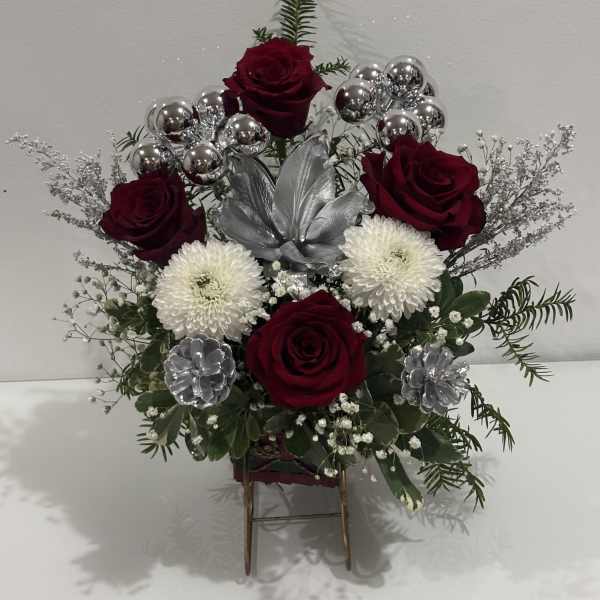 Arrangement of red roses and white mums with silver accents in a stand
