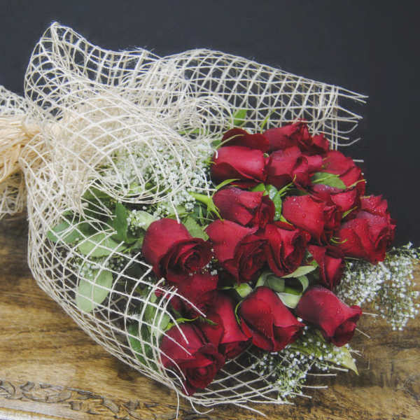 Bouquet of red roses wrapped in white mesh