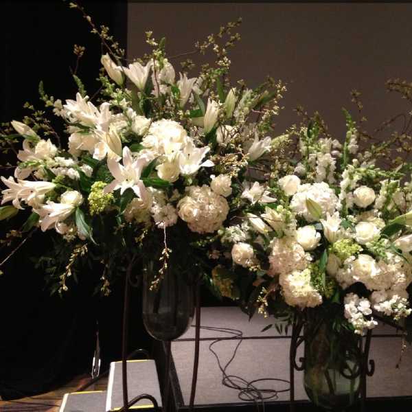 Large white floral arrangements in tall glass vases