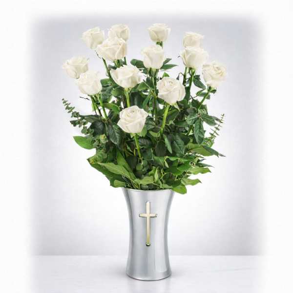White roses in a silver vase with a cross emblem