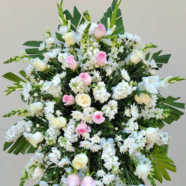 Large standing floral spray with white and pink roses and white daisies