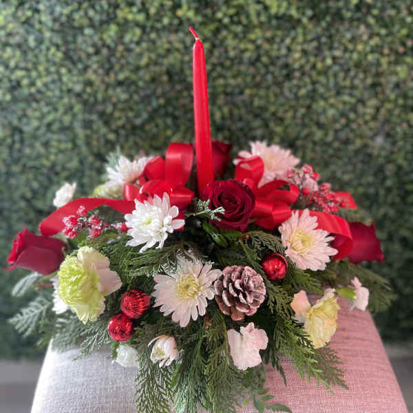 Holiday centerpiece with red candle, roses, and white flowers
