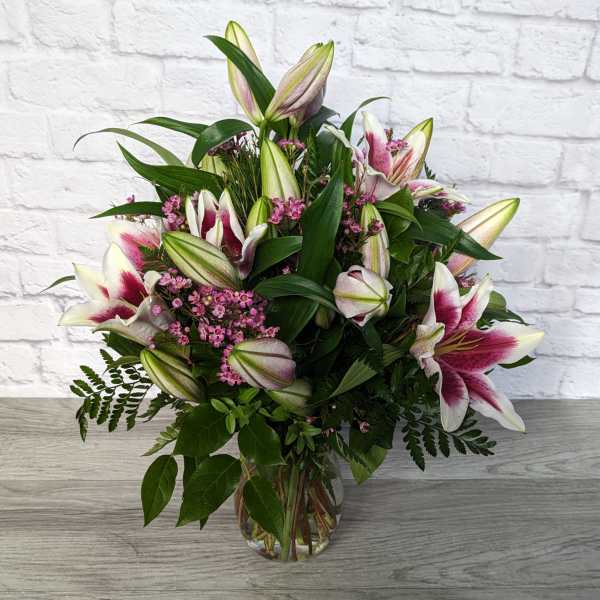 Bouquet of pink-and-white lilies in a glass vase