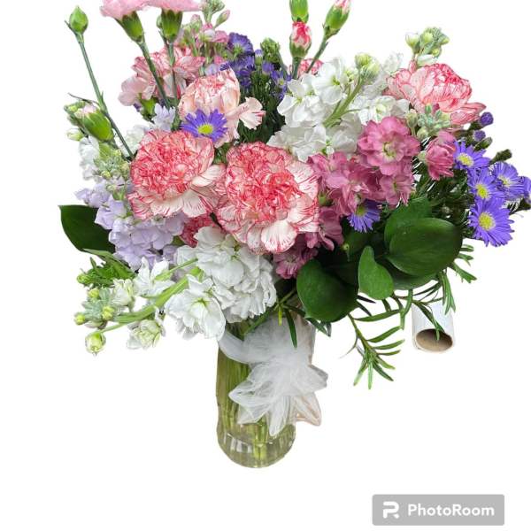 Mixed bouquet of pink, white, and purple flowers in a glass vase