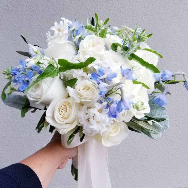 White rose bouquet with pale blue flowers and ribbon wrap