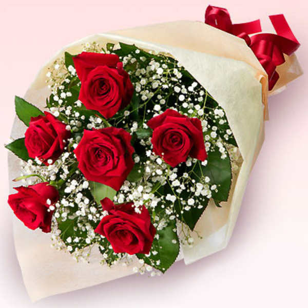 Bouquet of red roses with baby's breath wrapped in cream paper