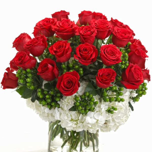 Red roses and white carnations in a clear glass vase