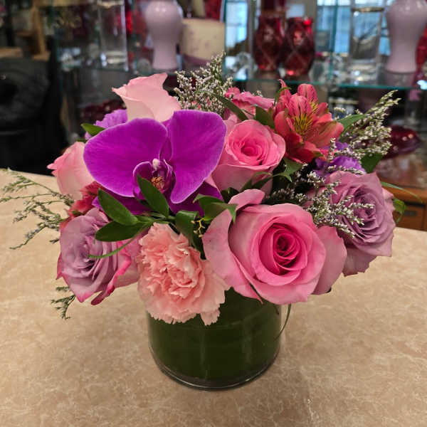 Pink and purple flower arrangement in a glass vase