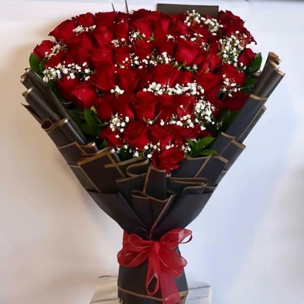 Bouquet of red roses with white baby's breath in black wrap