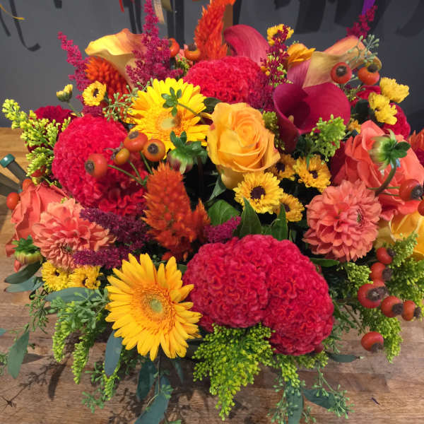 Bright mixed bouquet with yellow daisies, orange roses, and red blooms