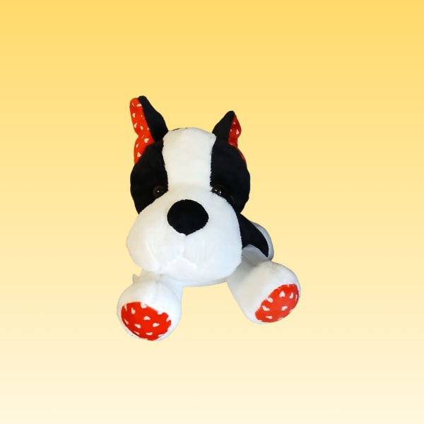 Black-and-white plush dog with red polka-dot ears and paws