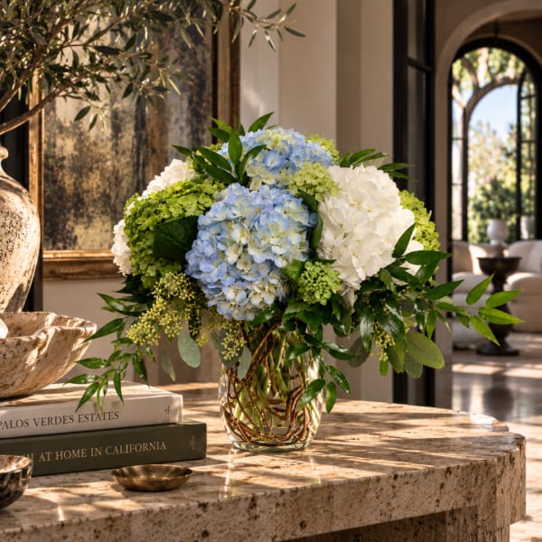 Blue and white hydrangea arrangement in a glass vase