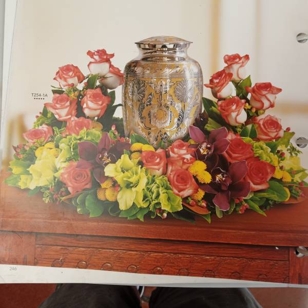 Floral arrangement around a silver urn with pink roses and orchids
