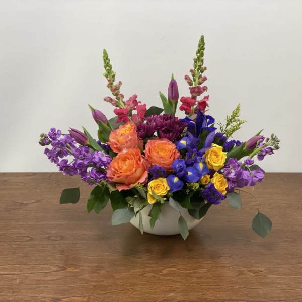 Colorful mixed flower arrangement in a white bowl vase