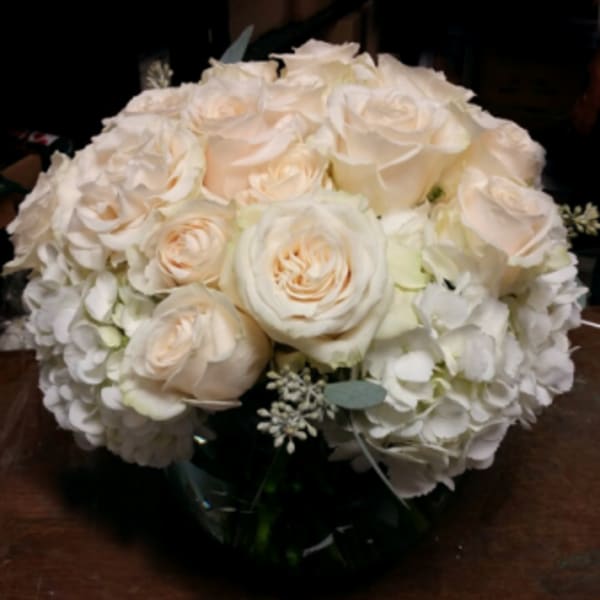 Cream rose bouquet with white hydrangeas in a glass vase