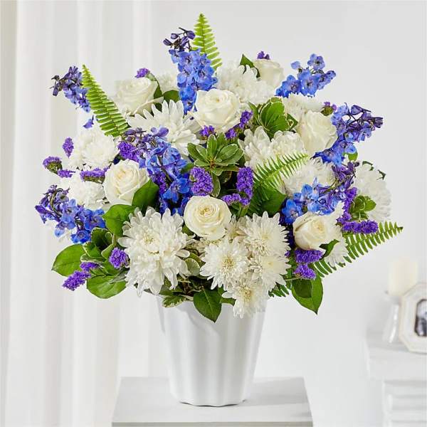 White and blue floral arrangement in a white vase