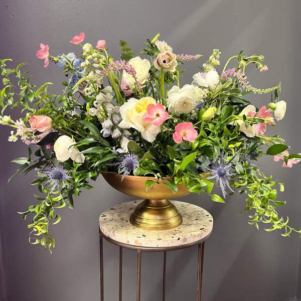 Large mixed floral arrangement in a gold pedestal bowl