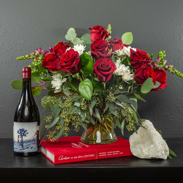 Bouquet of red roses and white daisies in a glass vase