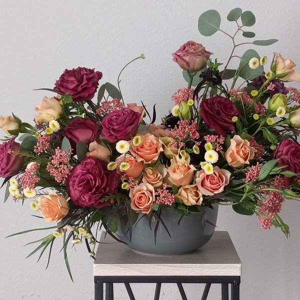 Mixed pink and peach roses in a gray bowl vase