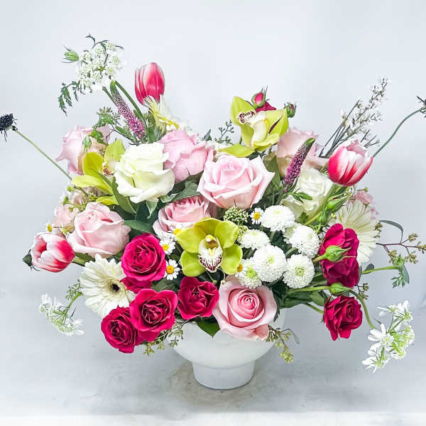 Mixed bouquet of pink and white flowers in a white vase