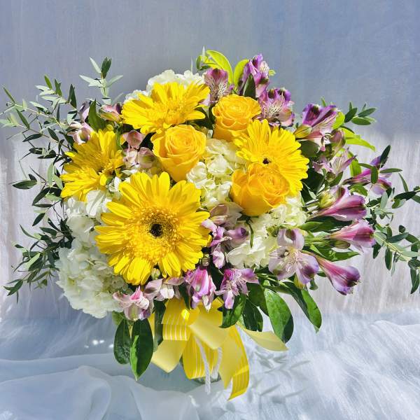 Yellow roses and gerbera daisies with white hydrangeas and pink alstroemeria
