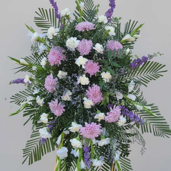 Large standing floral spray with pink and white blooms on an easel