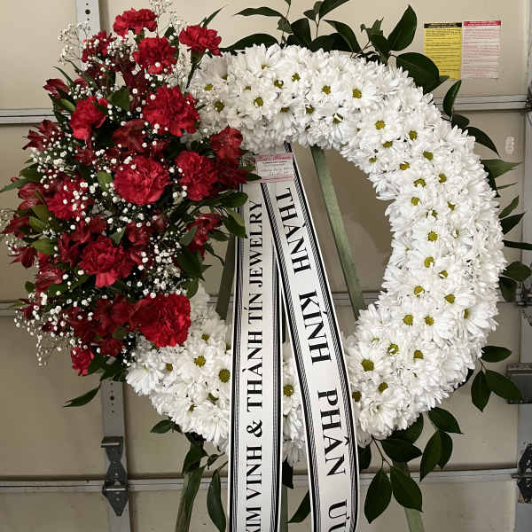 Red and white funeral wreaths with ribbon streamers
