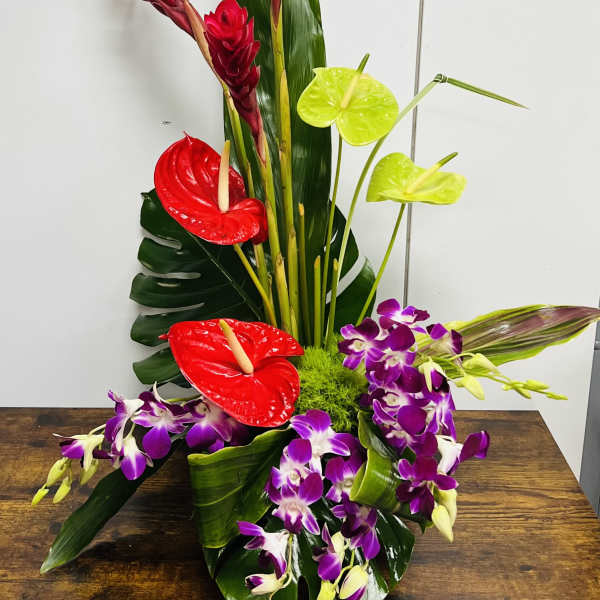 Tropical arrangement with red anthuriums, purple orchids, and tall red ginger flowers