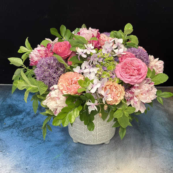 Pink and peach mixed flower arrangement in a patterned ceramic vase