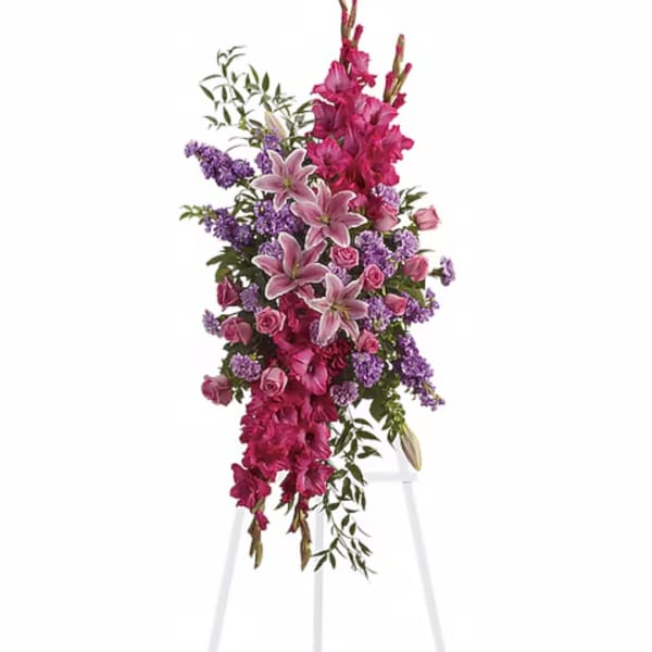 Tall pink and purple floral arrangement on a white stand
